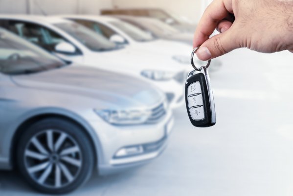 bumper to bumper car warranty hand holding car key cars parked in line